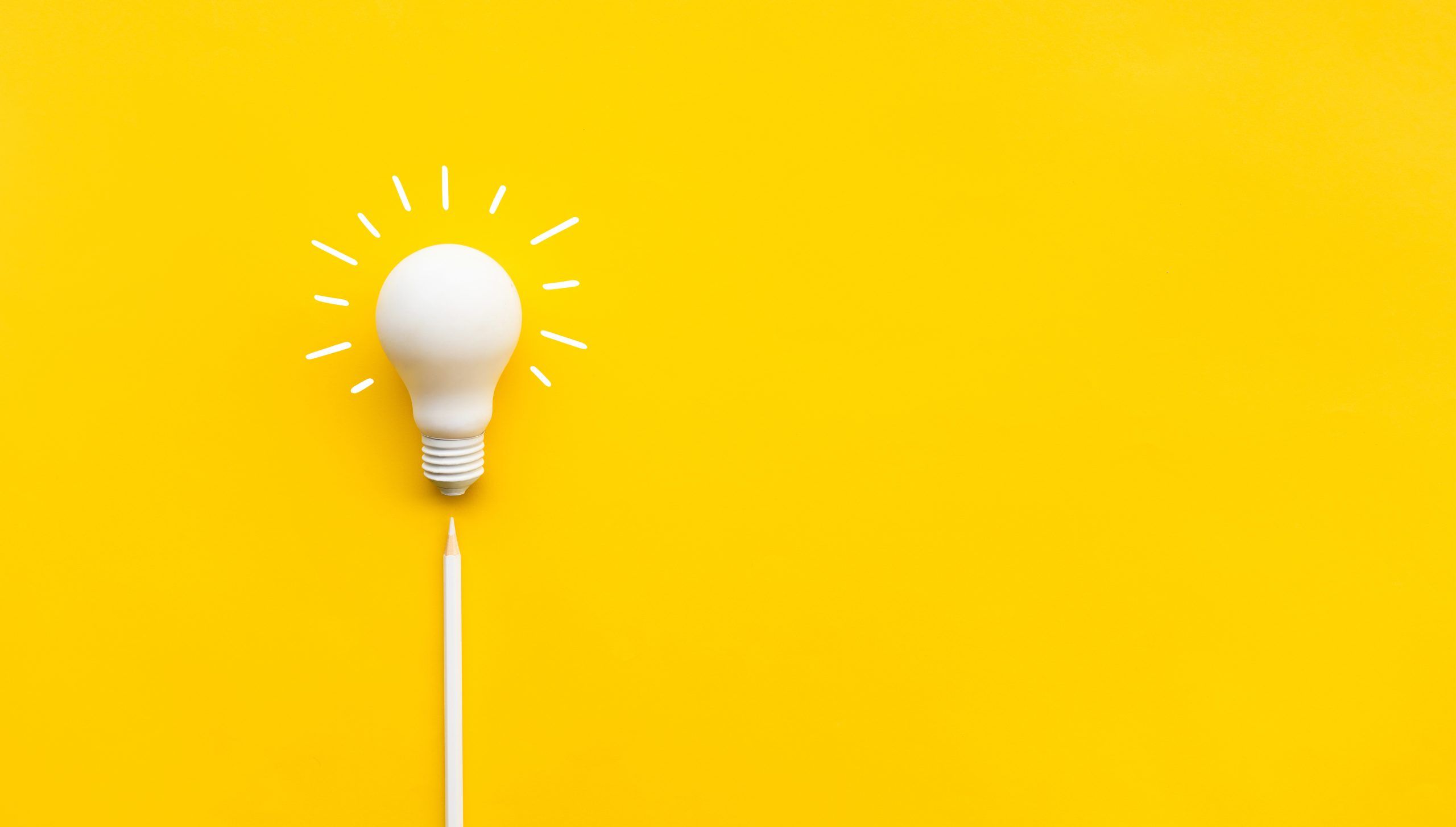 A white lightbulb with lines around it against a yellow background.